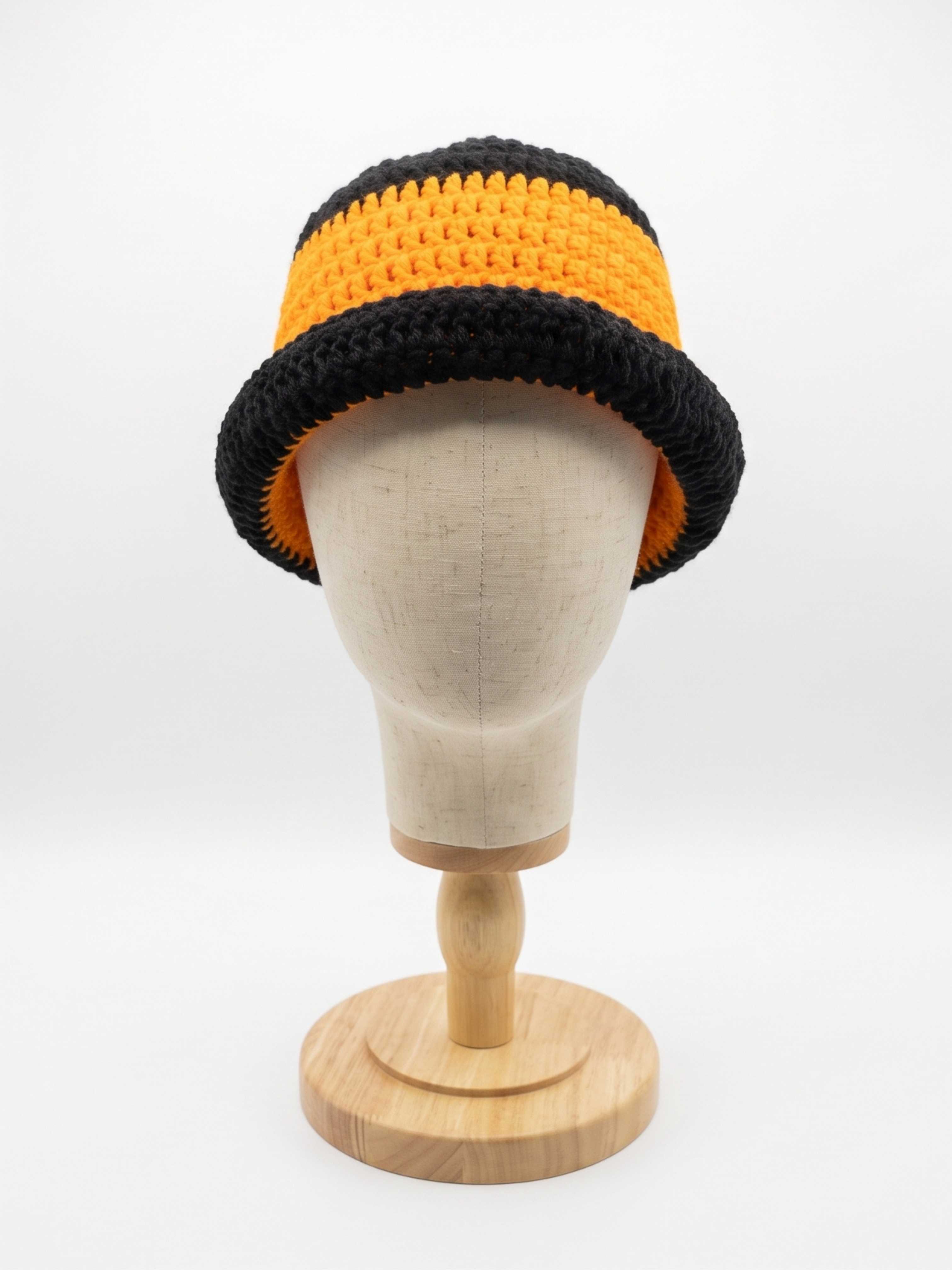 Orange crochet hat with black stripe and rolled black brim