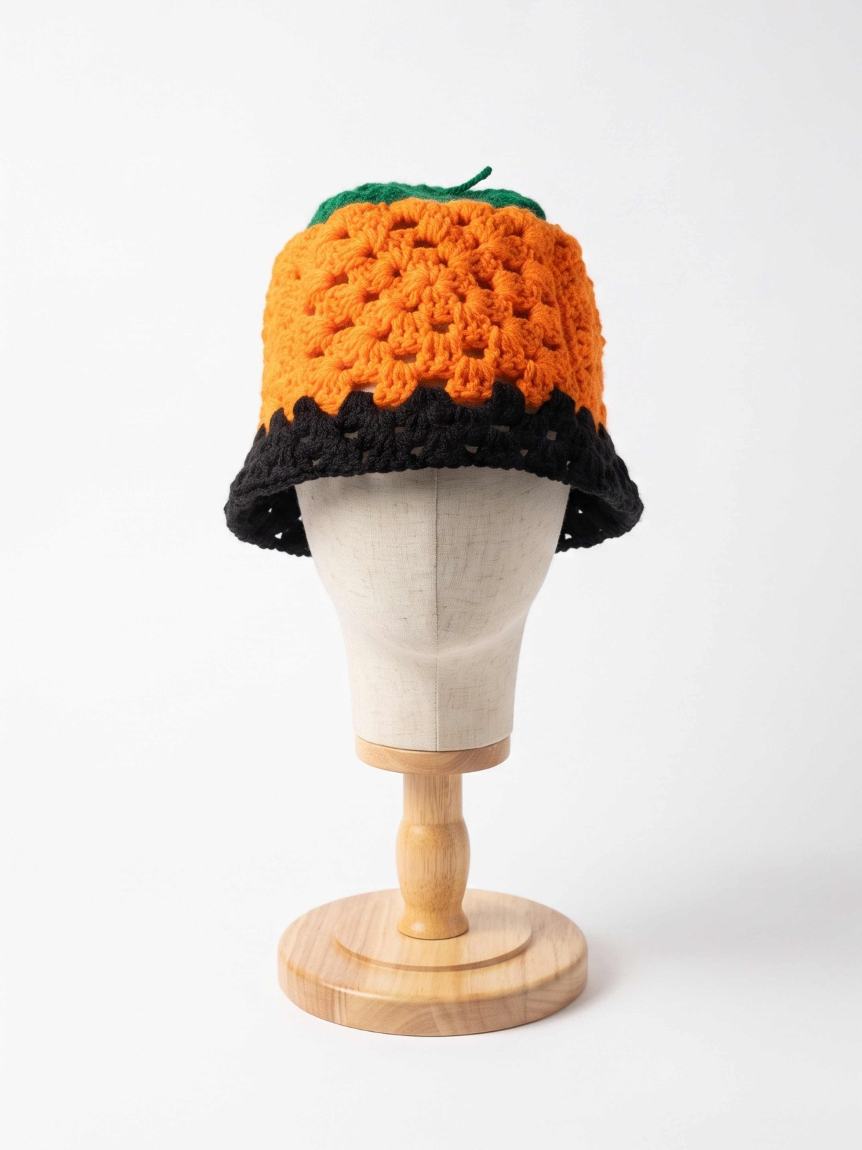 Orange crochet hat with green patch and black scalloped brim