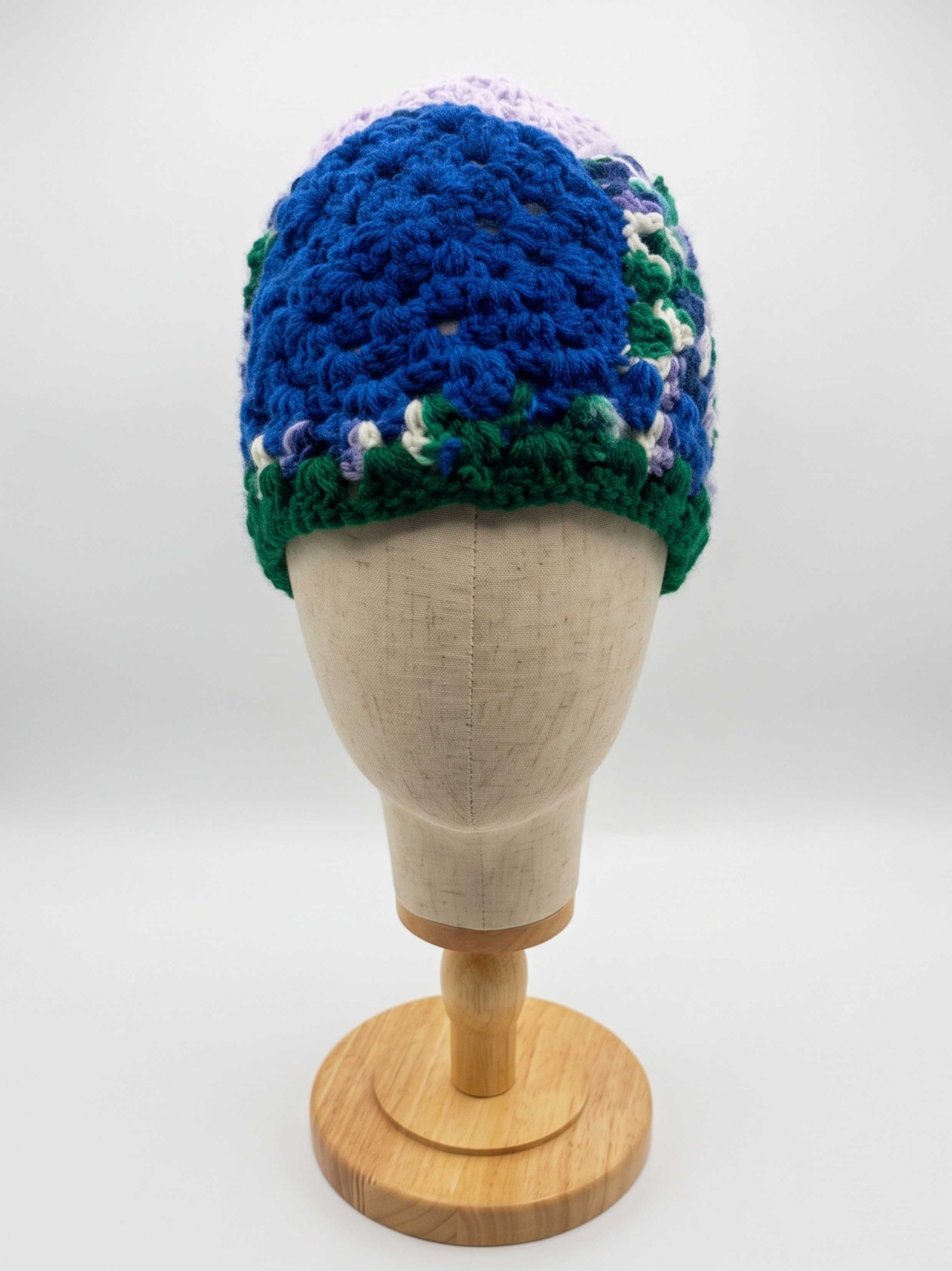 Royal blue crochet beanie with green, lavender, and white trim